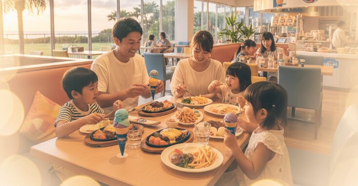 明るく広々としたレストランで、子供たちと一緒に食事を楽しむ家族。家族連れでも安心して利用できる北谷ディナーのお店。