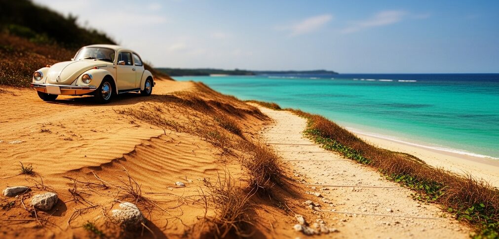 沖縄の恋人ビーチの駐車場情報をイメージさせる、海沿いの道に停められた車。青い海と空が広がる沖縄らしい風景で、ドライブの楽しさを感じさせる一枚。
