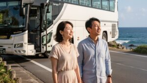 沖縄の海沿いに停車する、高級感のある観光バスと30代40代の男女。普通の路線バスとは違う、沖縄の婚活バスツアーならではの非日常的な旅の始まりを表現しています。