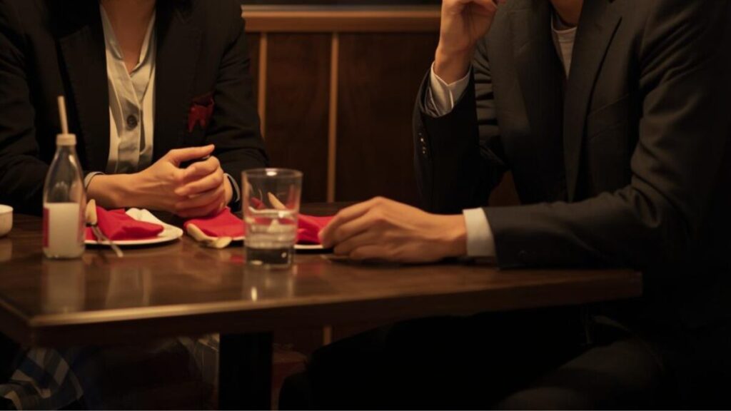 夜のレストランで真剣に会話を交わす30から40代の日本人男女。二人の表情は、交際へ進むかどうかのマッチングアプリで2回目に会う基準を確かめ合っているようです。